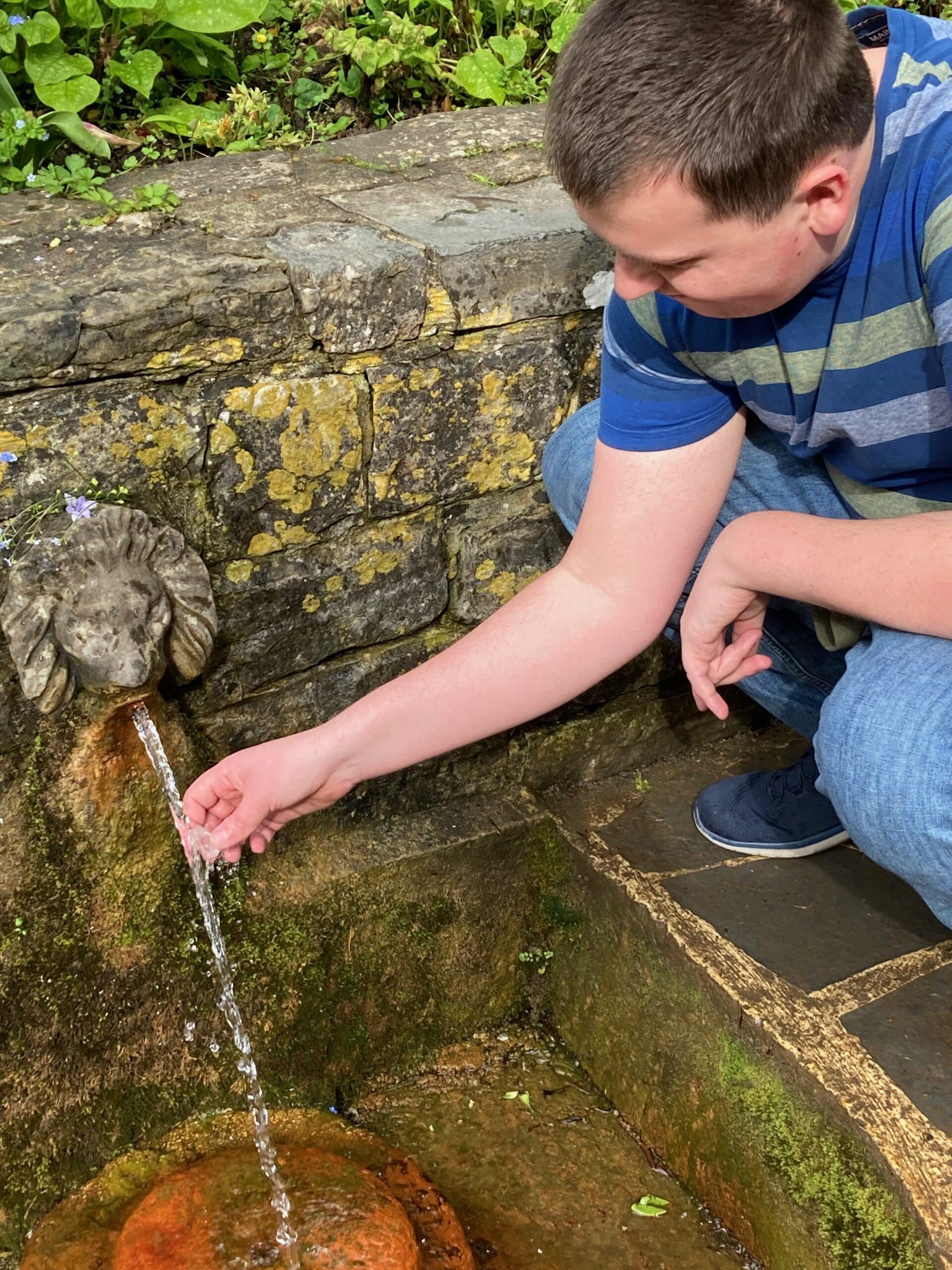 Jonathon cleansing crystal within Chalice Well in Glastonbury